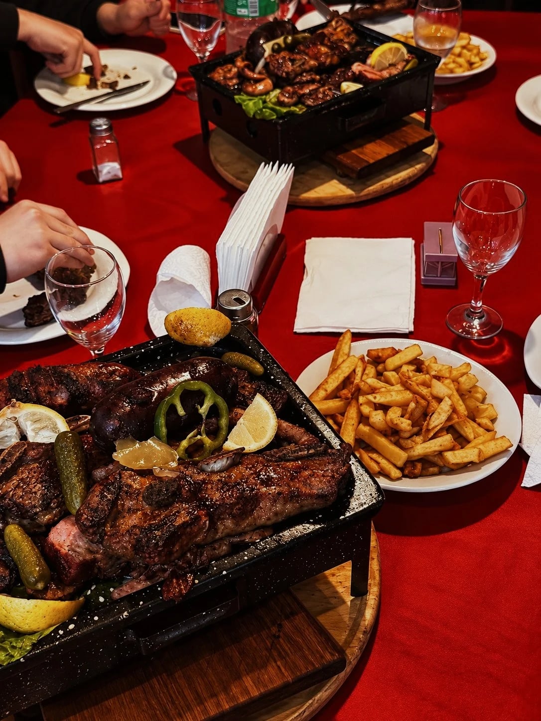 Parrilladas y papas fritas en una mesa para compartir
